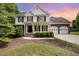 Charming two-story home featuring a covered porch and a two-car garage at dusk at 84 Sycamore Lake Rd, Siler City, NC 27344