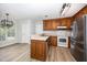Well-lit kitchen with light countertops, wooden cabinets, and stainless steel appliances at 84 Sycamore Lake Rd, Siler City, NC 27344