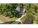 Aerial view showcases home's placement amidst lush trees, complete with a driveway and pristine lawn at 909 Alderleaf Dr, Fuquay Varina, NC 27526