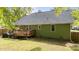 Expansive backyard featuring a wooden deck, lush lawn, and charming green exterior at 909 Alderleaf Dr, Fuquay Varina, NC 27526