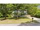 Traditional home with a manicured front yard and driveway, nestled among mature trees at 909 Alderleaf Dr, Fuquay Varina, NC 27526
