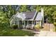 Charming green home with gray roof, black shutters, solar panels, manicured lawn, and appealing curb appeal at 909 Alderleaf Dr, Fuquay Varina, NC 27526