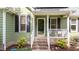 Inviting entrance with green siding, white railing, and address number above the black front door at 909 Alderleaf Dr, Fuquay Varina, NC 27526