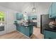 Stylish kitchen with blue cabinets, black countertops, modern appliances, and a door to the outside at 909 Alderleaf Dr, Fuquay Varina, NC 27526