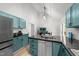 Bright eat-in kitchen features stainless appliances, turquoise cabinetry, and a center island with breakfast bar at 909 Alderleaf Dr, Fuquay Varina, NC 27526