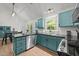 Spacious kitchen with blue cabinets, black countertops, stainless steel appliances, and a view into the dining area at 909 Alderleaf Dr, Fuquay Varina, NC 27526