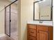 Bathroom featuring wood cabinets, granite countertops, large mirror, and walk-in shower with glass enclosure at 924 Carolina Bell Rd, Apex, NC 27502