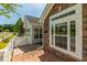 Detailed view showing stone accents, large window, brick paver patio, and white picket fence at 924 Carolina Bell Rd, Apex, NC 27502