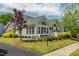Attractive gray home featuring stone accents, well-maintained landscaping, and a charming white picket fence at 924 Carolina Bell Rd, Apex, NC 27502