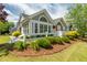 Charming gray home featuring attractive stone accents, manicured landscaping, and a white picket fence at 924 Carolina Bell Rd, Apex, NC 27502