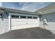 Garage with paneled white doors, carriage accents, and blacktop driveway at 924 Carolina Bell Rd, Apex, NC 27502