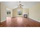 Bright living room with hardwood floors, a ceiling fan, and a cozy fireplace at 924 Carolina Bell Rd, Apex, NC 27502