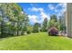 Backyard with a lush green lawn, mature trees, and patio seating at 10 Marsh Landing Ct, Durham, NC 27703