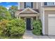 A covered front entrance with a dark door is framed by lush greenery and blue shutters at 10 Marsh Landing Ct, Durham, NC 27703