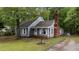 View of the home's exterior, showcasing landscaping and a brick chimney at 1100 Cardinals Knob, Rocky Mount, NC 27804