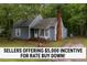 Charming cottage-style home with a brick chimney, mature trees, and blue siding at 1100 Cardinals Knob, Rocky Mount, NC 27804