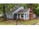 Charming home showcasing grey siding, brick chimney and a delightful front garden at 1100 Cardinals Knob, Rocky Mount, NC 27804
