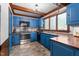 Bright kitchen with blue cabinetry, stainless steel appliances, and a cozy corner view at 1100 Cardinals Knob, Rocky Mount, NC 27804