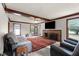Spacious living room features a brick fireplace, ceiling beams, and ample natural light at 1100 Cardinals Knob, Rocky Mount, NC 27804