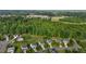 Aerial view showing neighborhood homes bordering on a lush green forest at 1301 Torrey Pines Ct, Mebane, NC 27302