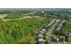 An aerial view of a neighborhood featuring backyards, a green space, and mature trees at 1301 Torrey Pines Ct, Mebane, NC 27302
