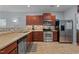 Functional kitchen boasts stainless steel appliances, a tiled floor, and wood cabinets at 1301 Torrey Pines Ct, Mebane, NC 27302