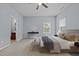 Bright main bedroom features neutral decor, a decorative round mirror, and doorway to the bathroom at 1301 Torrey Pines Ct, Mebane, NC 27302