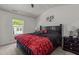 Vaulted ceiling primary bedroom with large window, ceiling fan and a bold red and black color scheme at 1574 Dorsett Ln, Creedmoor, NC 27522