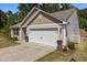 Side angle of a home's garage, with a concrete driveway and manicured landscaping at 1574 Dorsett Ln, Creedmoor, NC 27522