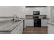 Modern kitchen features stainless steel sink, granite countertops, updated appliances and white cabinets at 1574 Dorsett Ln, Creedmoor, NC 27522