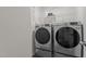 Modern laundry room featuring a washer and dryer set with a shelf for laundry supplies at 1574 Dorsett Ln, Creedmoor, NC 27522