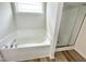 Bathroom featuring a relaxing soaking tub with shower and window for natural light at 158 Sourgum Ct, Zebulon, NC 27597