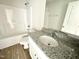 Bathroom featuring a white vanity with granite countertop, shower over tub and neutral paint at 158 Sourgum Ct, Zebulon, NC 27597