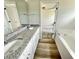 Bathroom showcasing dual granite vanity, soaking tub and an open doorway to main bedroom at 158 Sourgum Ct, Zebulon, NC 27597