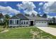 Charming single-story home with a manicured lawn and a two-car garage on a sunny day at 158 Sourgum Ct, Zebulon, NC 27597