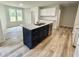 Modern kitchen with a navy island, white cabinets, granite countertops, and stainless steel appliances at 158 Sourgum Ct, Zebulon, NC 27597