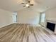 Light-filled living room with vaulted ceilings, ceiling fan, and wood-look floors with a fireplace at 158 Sourgum Ct, Zebulon, NC 27597