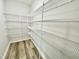 Walk-in pantry with shelving for organized storage and wood-look flooring at 158 Sourgum Ct, Zebulon, NC 27597