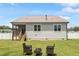 Back exterior of home, featuring a screened-in porch, and backyard seating area with two Adirondack chairs at 164 Wilson Farm Ln, Clayton, NC 27527