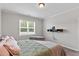 Bright bedroom featuring modern gray flooring, a comfortable bed, a window, and a floating media console at 164 Wilson Farm Ln, Clayton, NC 27527