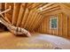Unfinished attic space showcasing the home's wood frame construction and a single window at 188 Buckaroo Dr, Louisburg, NC 27549