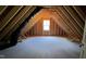 Unfinished attic space with exposed wooden beams and a dormer window at 188 Buckaroo Dr, Louisburg, NC 27549