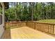Wooden backyard deck with a railing, offering a view of the surrounding greenery at 188 Buckaroo Dr, Louisburg, NC 27549