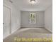 Bright bedroom with a large window offering outdoor views, complemented by neutral carpet and white trim at 188 Buckaroo Dr, Louisburg, NC 27549