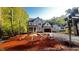 Under-construction two-story home with a two-car garage and an unfinished yard surrounded by trees at 188 Buckaroo Dr, Louisburg, NC 27549