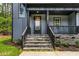 Close-up of the front porch of a modern home with black railings and stone accents on a well-kept lawn at 188 Buckaroo Dr, Louisburg, NC 27549