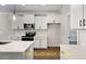 Elegant kitchen featuring white cabinets, stone backsplash, stainless steel appliances, and countertop island at 188 Buckaroo Dr, Louisburg, NC 27549