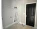 Laundry room with black door, overhead shelf and washer dryer hookups at 188 Buckaroo Dr, Louisburg, NC 27549