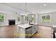 Open living space with a kitchen island, fireplace, windows, and hardwood flooring at 188 Buckaroo Dr, Louisburg, NC 27549