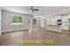 Open concept living room area featuring a fan, multiple windows, white cabinets, and wood floors at 188 Buckaroo Dr, Louisburg, NC 27549